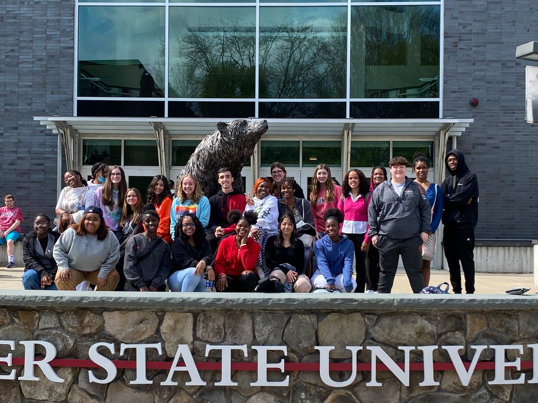 A group of students standing in front of a Bear Statue